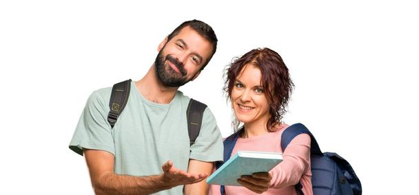 孤立した白い背景にバックパックや本を持つ2人の学生を幸せに - 写真・画像