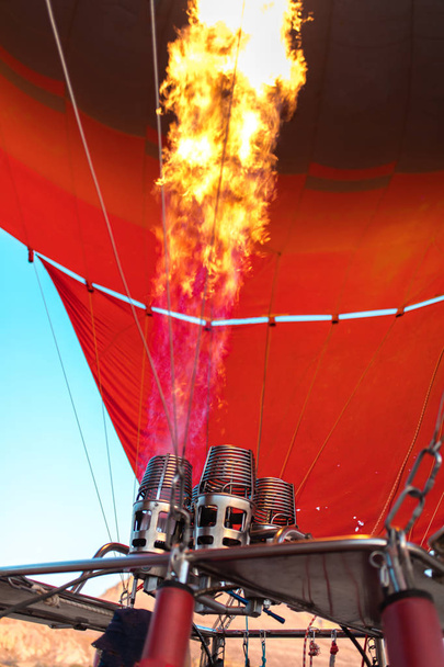 熱気球は、ネフセヒル、ゴレメ、カッパドキアトルコのガスバーナー火災で膨張またはインフレ。壮大なカッパドキアトルコで飛行に準備熱気球.   - 写真・画像