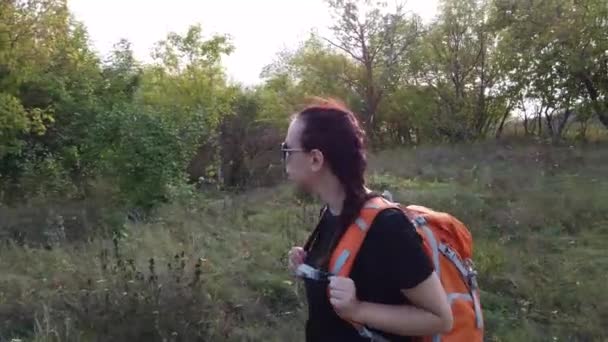 young woman with backpack walking  in  park - Materiaali, video