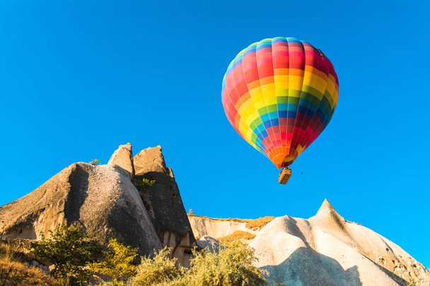 Kleurrijke hete lucht ballonnen vliegen over op sprookjesachtige schoorstenen in Nevsehir, Göreme, Cappadocië Turkije. Hete lucht ballonvlucht bij spectaculaire Cappadocië Turkije. - Foto, afbeelding