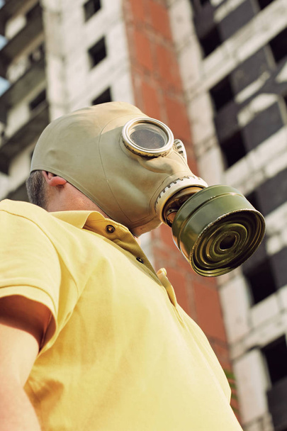 Human in gas mask on destroyed building background.  - Foto, Bild