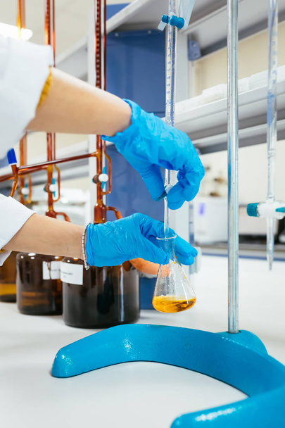 Nő vagy női kéz védőkesztyűben tartsa kémcsövet a kezében termel kémia kísérlet teszt és kutatás a modern kémia labor.  - Fotó, kép