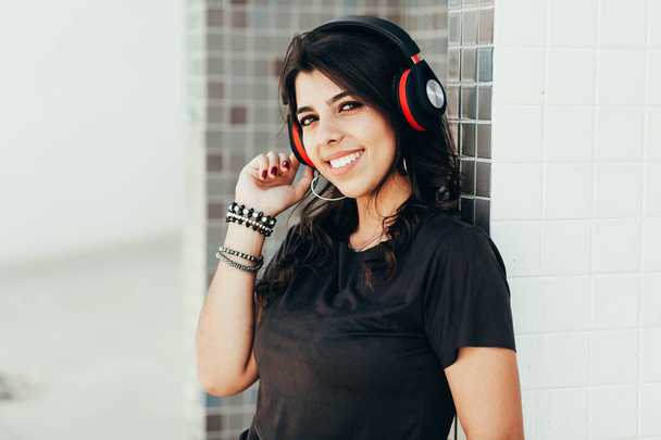 Fiatal szép nő használ fejhallgató hallgató-hoz zene szabadban történő - Fotó, kép