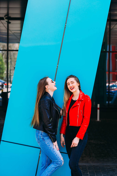 young girls standing together in leather jacket near building an - Фото, зображення