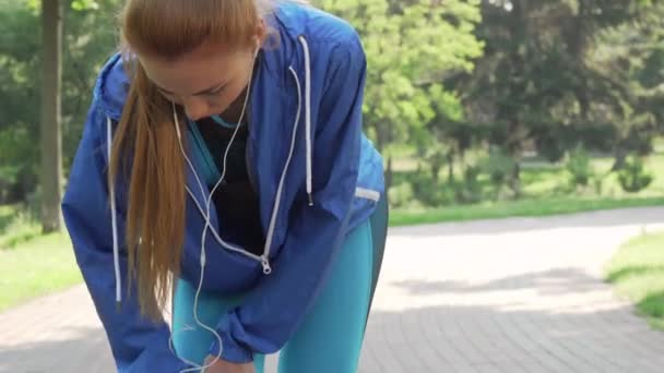 Κομμένο σφηνάκι από μια αθλήτρια που τρίβει το τραυματισμένο γόνατό της μετά το τρέξιμο - Πλάνα, βίντεο