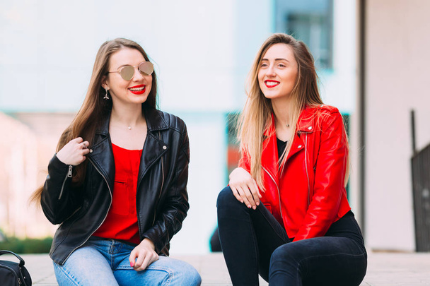 girls sitting and smile. Wearing trendy urban outfit, leather ja - Photo, Image