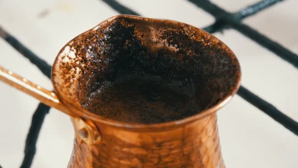 Βραστό μαύρο καφέ σε έναν Τούρκο από χαλκό σε σόμπα με άσπρη βενζίνη. - Πλάνα, βίντεο