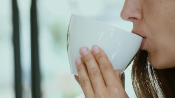 Fiatal nő iszik reggeli kávét - Felvétel, videó