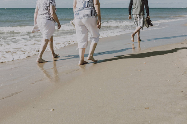Des retraités se promènent sur la plage
 - Photo, image