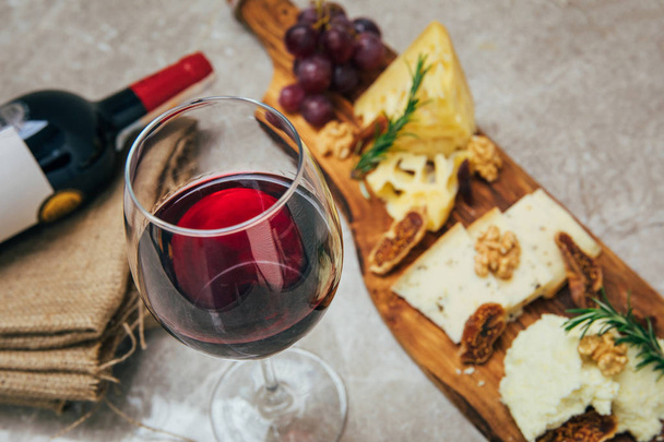 Pohár bor és sajt. Választék, vagy a sajt és a borospohár különféle fajtája az étteremben az asztalon. Vörös, rózsa és sárga bor vagy pezsgő az asztalnál. Borászat-koncept Image - Fotó, kép