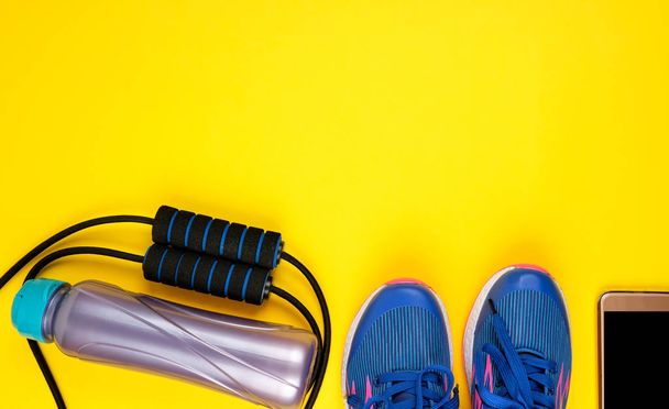 παπούτσια μπλε γυναικών και σχοινί άλμα για αθλήματα και fitness σε ένα  - Φωτογραφία, εικόνα