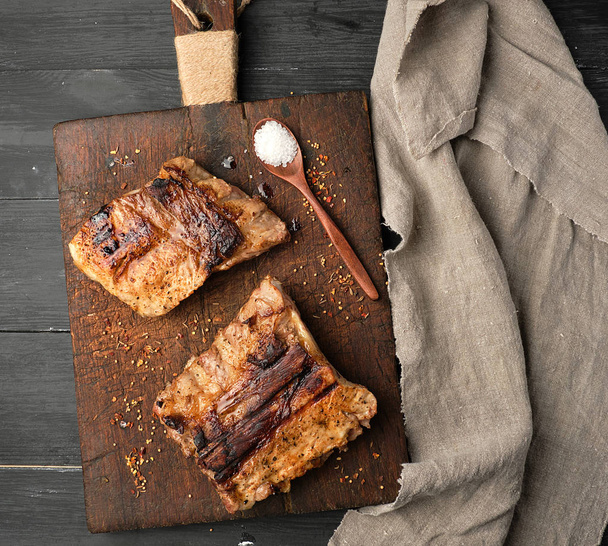 grilled pork ribs on a brown wooden cutting board, - Photo, Image