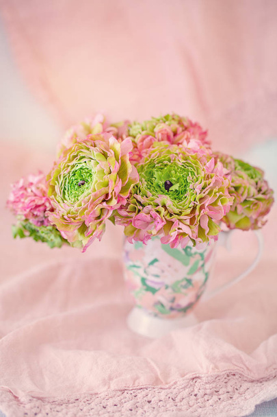 A beautiful bouquet of spring flowers on a pink background on the table with a tablecloth. Pastel colors. - Foto, immagini