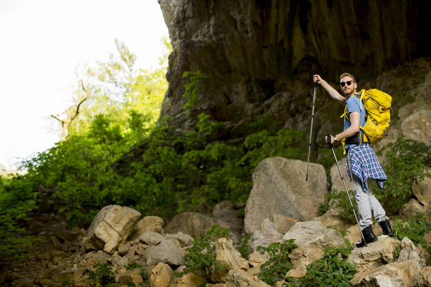Przystojny młody kaukaski mężczyzna Hiker z plecak turystyka w słoneczny dzień - Zdjęcie, obraz