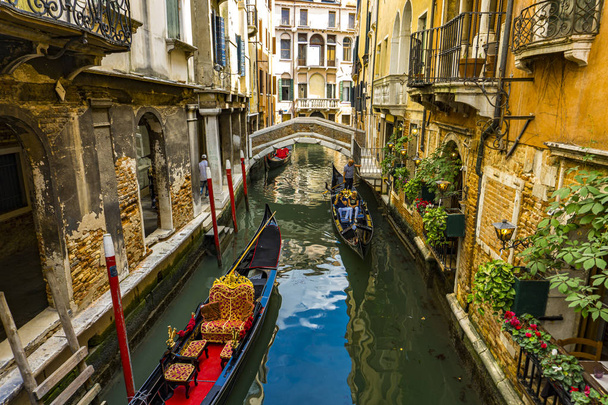 VENECIA, ITALIA - 26 DE MAYO DE 2019: Personas no identificadas en la góndola tradicional en el estrecho canal de Venecia, Italia. En los siglos XVII y XVIII se estimó que la ciudad tiene 10.000 góndolas
. - Foto, Imagen