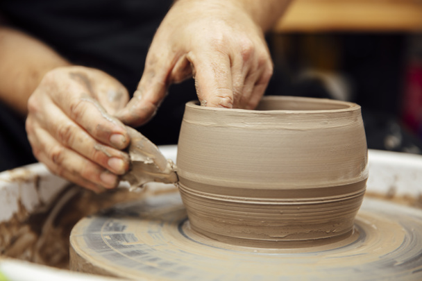 Vista de detalhe de perto em um artista de correio faz cerâmica de barro em uma roda de giro
 - Foto, Imagem