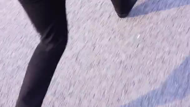 Houng homem vestindo calças pretas e jaqueta de couro preto corre no pavimento
. - Filmagem, Vídeo