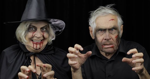 Homem e mulher idosos disfarçados de Halloween. Dripando sangue em seus rostos
 - Foto, Imagem