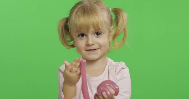 Criança brincando com lodo de brinquedo feito à mão. Criança se divertindo fazendo lodo rosa
 - Foto, Imagem