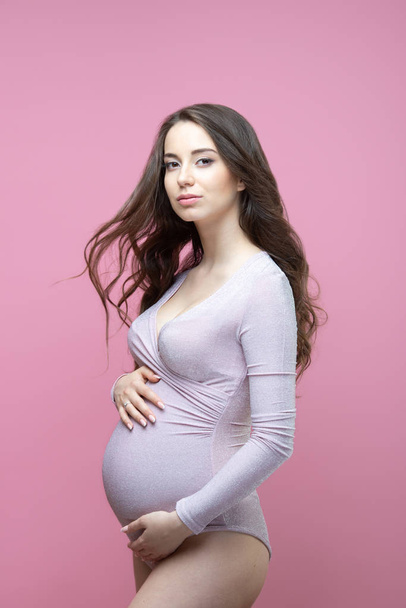 Beautiful young pregnant woman with flowing long wavy hair stand - Φωτογραφία, εικόνα