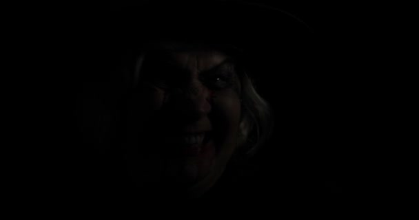 Old witch Halloween makeup. Elderly woman portrait with blood on her face. - Footage, Video