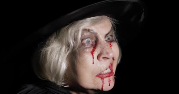 Oude heks Halloween Make-up. Oudere vrouw portret met bloed op haar gezicht. - Video