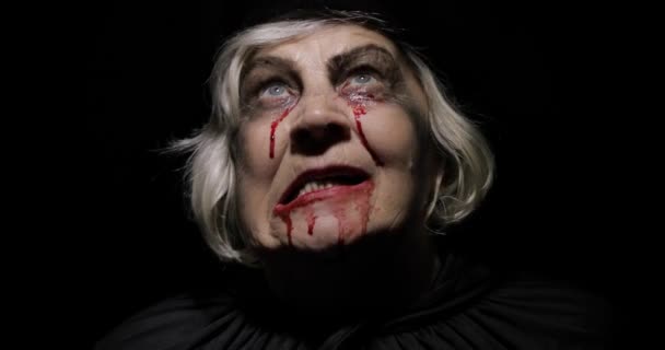 Yaşlı cadı Cadılar Bayramı makyajı. Yüzünde kan olan yaşlı kadın portresi. - Video, Çekim