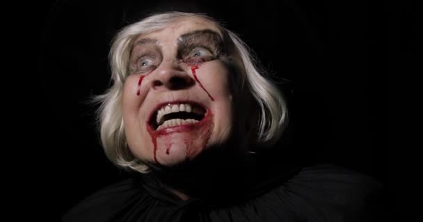 Stary czarownica Halloween makijaż. Portret kobiety w podeszłym wieku z krwią na twarzy. - Materiał filmowy, wideo