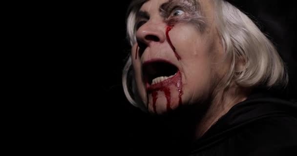 Maquillaje de Halloween de bruja vieja. Retrato de mujer anciana con sangre en la cara
. - Metraje, vídeo