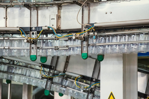 PET műanyag palackok mozog automata szállítószalag vagy öv a vízgyárban vagy a növényi termelés, közelről - Fotó, kép