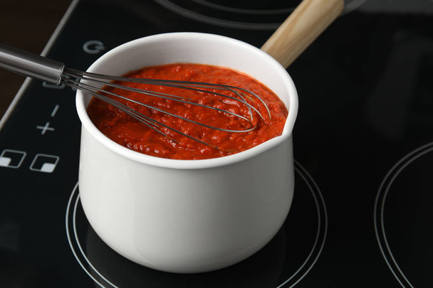 Cooking delicious tomato sauce in pan on stove, closeup - Photo, Image