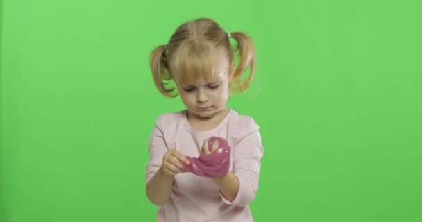 Kind spielt mit handgemachtem Spielzeugschleim. Kind hat Spaß bei der Herstellung von rosa Schleim - Filmmaterial, Video