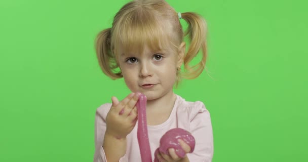 Kind spielt mit handgemachtem Spielzeugschleim. Kind hat Spaß bei der Herstellung von rosa Schleim - Filmmaterial, Video
