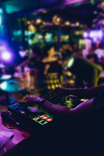 Auf der Bühne im Nachtclub legt DJ Live-Set auf und mischt Musik auf dem Plattenspielerpult. Disc Jokey Hands auf einem Soundmischpult bei einer Clubparty. DJ-Mischpult-Bedienfeld für Musik und Party. - Foto, Bild