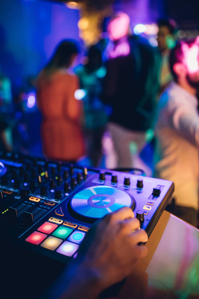 DJ грає в прямому ефірі і змішує музику на консолі на сцені нічного клубу. Диск Jokey Hands на звуковій мікшерній станції на вечірці клубу. Панель контролера DJ-мікшера для відтворення музики та вечірки
. - Фото, зображення