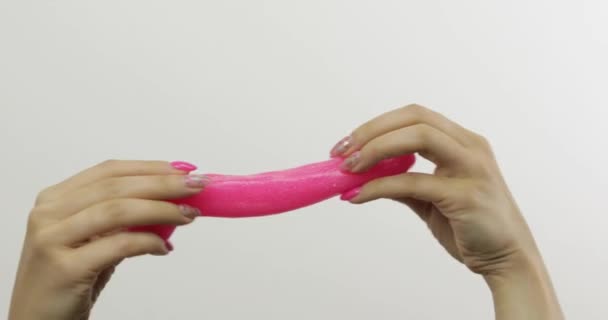 Vrouw handen spelen vreemd bevredigend roze slime op witte achtergrond. Antistress - Video