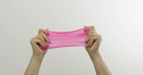 Руки жінки грають дивно задовольняючи рожевий слиз на білому тлі. антистрес
 - Кадри, відео