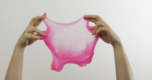 Mãos de mulher jogando lodo rosa estranhamente satisfatória no fundo branco. Antistress
 - Filmagem, Vídeo