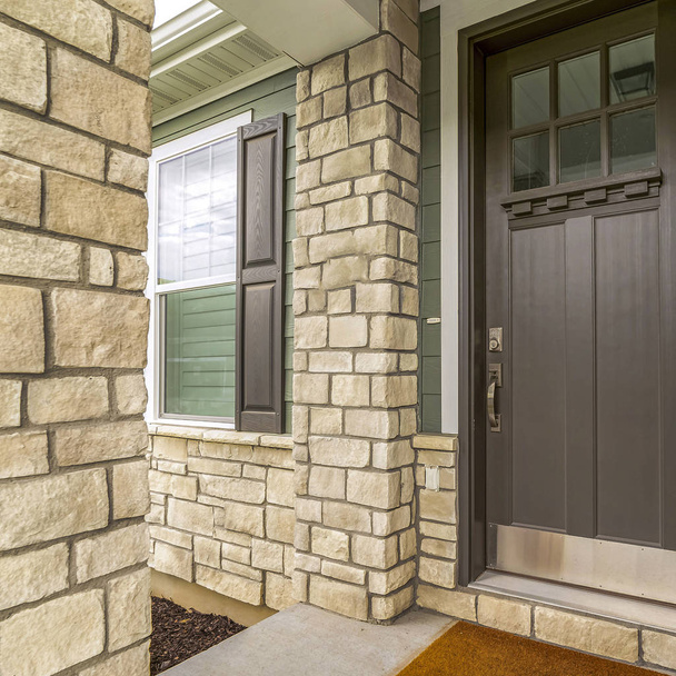Kwadratowa rama Wejście do domu ze szklanymi, brązowymi, drewnianymi drzwiami i ceglaną ścianą - Zdjęcie, obraz