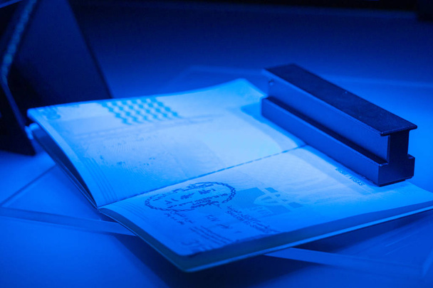 Ellenőrzése az útlevél a csalás UV és egy másik fény, det - Fotó, kép