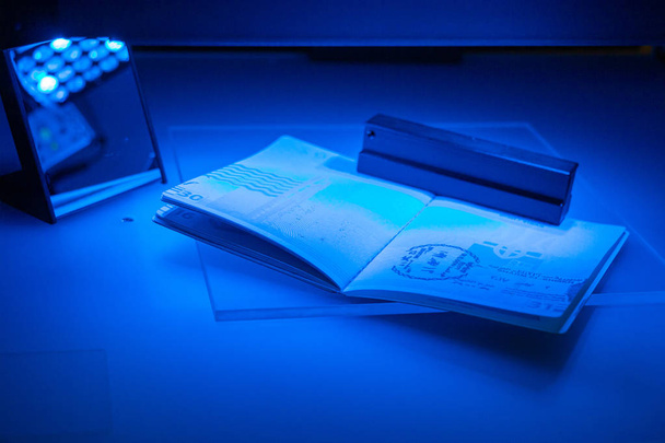 Ellenőrzése az útlevél a csalás UV és egy másik fény, det - Fotó, kép