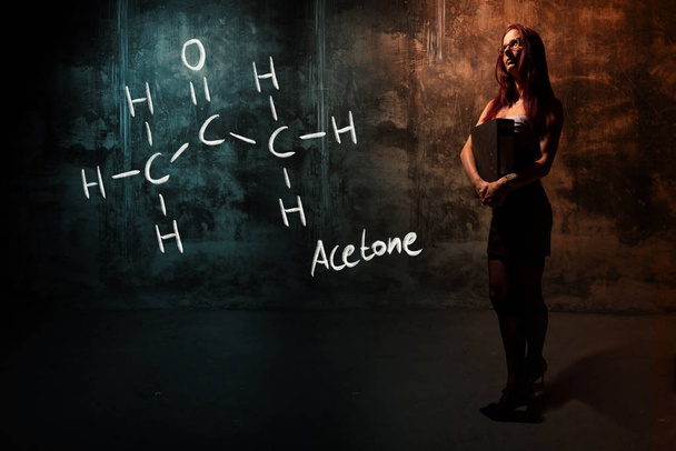 Sexy chica o secretaria o estudiante que presenta fórmula química dibujada a mano de acetona
 - Foto, Imagen