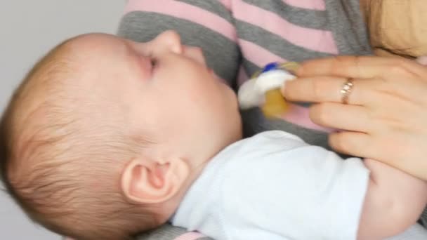 Un nouveau-né de deux mois se couche sur les bras de la mère et suce le mamelon. Mère essaie de faire dormir son enfant
 - Séquence, vidéo