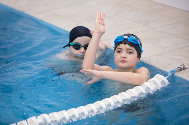Мальчики плавают в бассейне
 - Фото, изображение