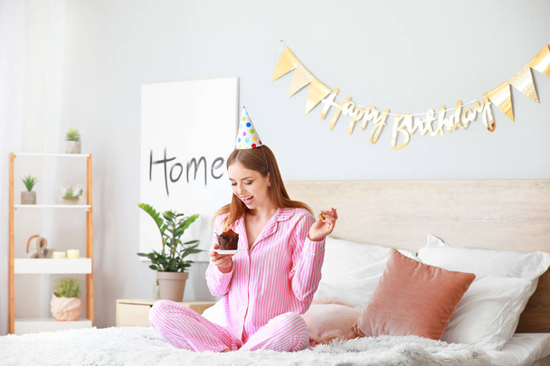 glückliche Frau mit Geburtstagstorte im Schlafzimmer zu Hause - Foto, Bild