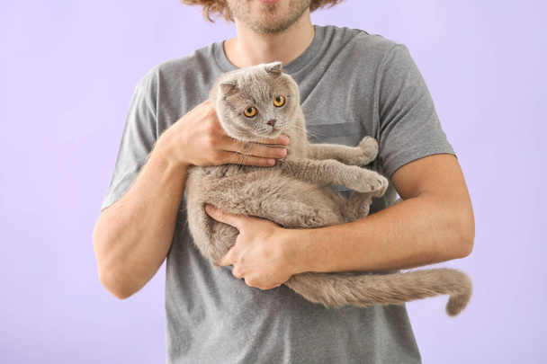 Man with cute funny cat on color background - Fotoğraf, Görsel