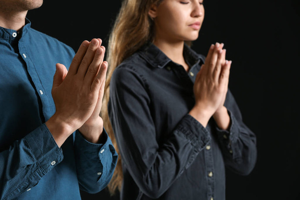 Para religijna modląca się do Boga na ciemnym tle - Zdjęcie, obraz