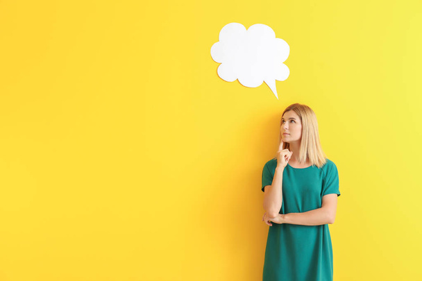 Thoughtful woman with speech bubble on color background - Photo, Image