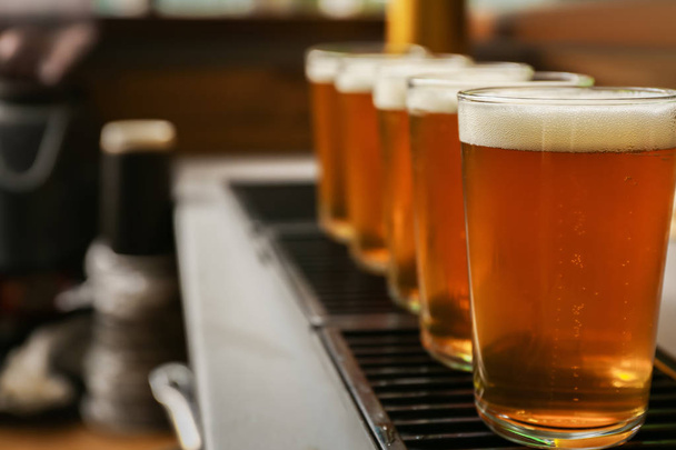 Glasses of fresh draft beer on bar counter - Foto, Imagen