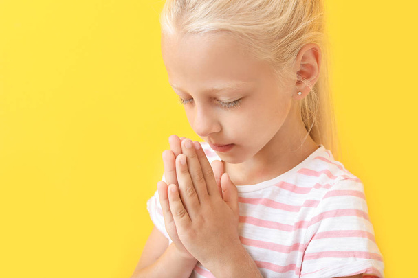 Little girl praying on color background - Foto, Bild